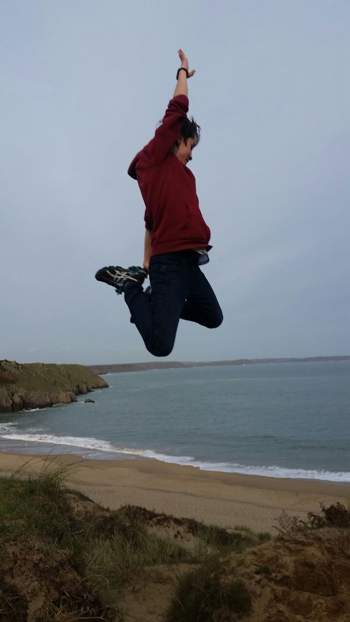 Koerpersprache - ein junger Mann springt in die Luft