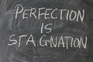 Schild mit Aufschrift: Perfection is Stagnation